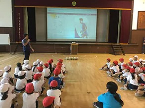 Shining Arcs player giving a presentation to students during a class